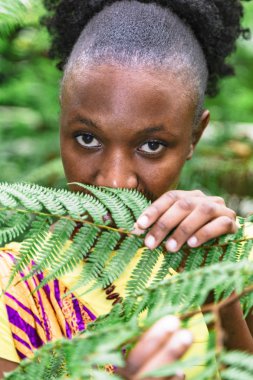Afrikalı kadın ormanda yeşil yaprakların arkasına saklandı