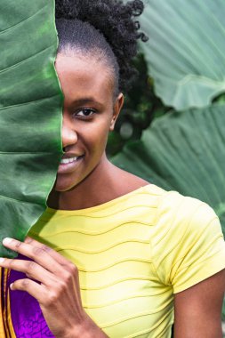Afrikalı kız palmiye yaprağı ve gülümsüyor arkasına saklandı