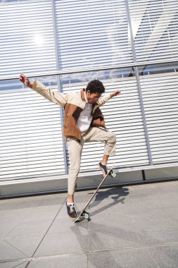 Afro adam ollie yapıyor ve havada paten kaldırır