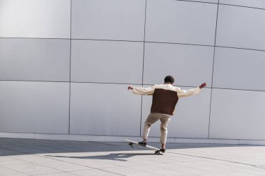 Afro kaykaycı açık havada beyaz hile yapıyor