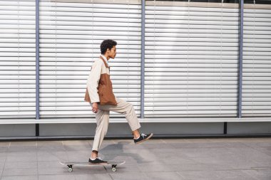 Afro-Amerikan adam tek ayak üzerinde kaykay üzerinde duruyor