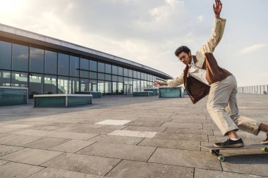 Afro adam kolları uzanmış kaykay sürmek