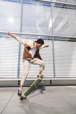 Afro adam ollie yapıyor ve havada paten kaldırır