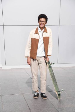 Afro-amerikan kaykaycı kamera içine tahta ile gülümsüyor