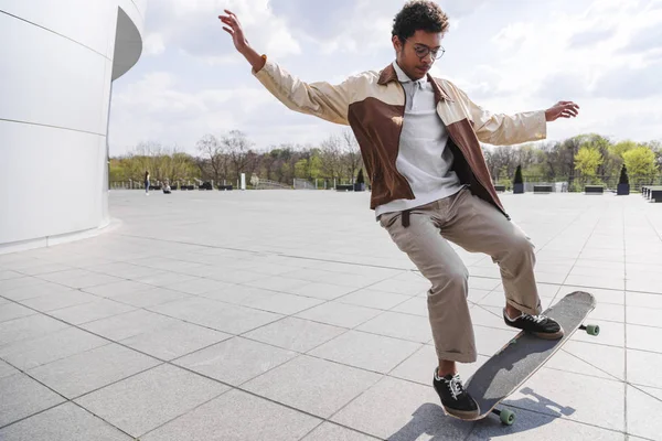 Afro kaykaycı binanın önünde ollie yok