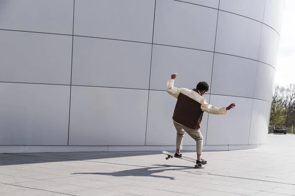 Афро скейтбордист на открытом воздухе делает трюк на белом — стоковое фото