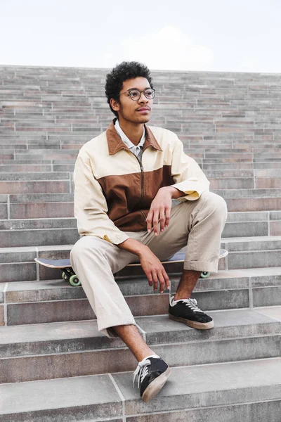 Afrikalı kaykaycı oturma ve merdivenlerde istirahat