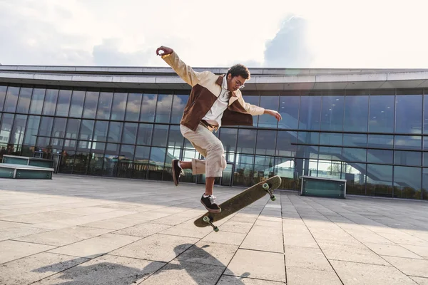 Afrikalı Amerikalı adam kaykay ile ollie yapıyor