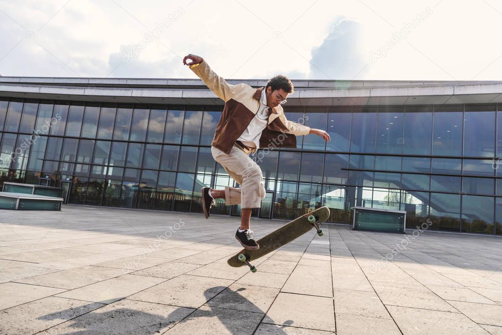 African american guy doing ollie with skateboard