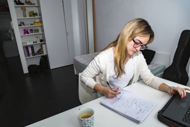 Kız freelancer dizüstü bilgisayarda yazma ve notlar alma