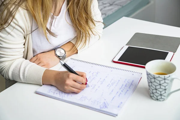 Ragazza impara e scrive in taccuino di carta con penna — Foto Stock