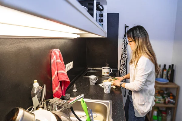 La ragazza in cucina prepara il tè e taglia il limone per esso — Foto Stock