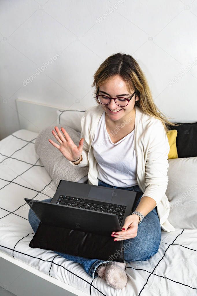 Girl communicates into laptop and raised her hand
