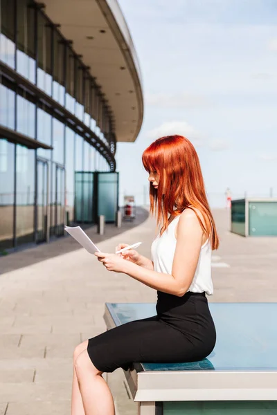 Young redhead business woman in formal outside