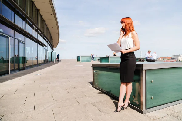 Young redhead business woman in formal outside