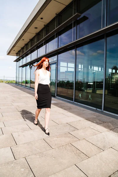 Young redhead business woman in formal outside