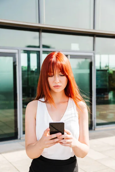 Retrato de menina ruiva usando seu telefone celular — Fotografia de Stock