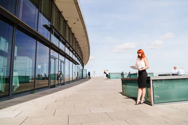 Young redhead business woman in formal outside