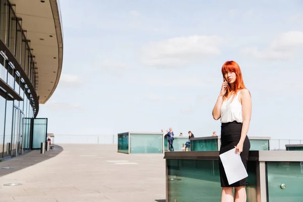 Young redhead business woman in formal outside
