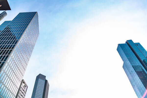 View of skyscrapers on background of bright blue sky with empty space for text