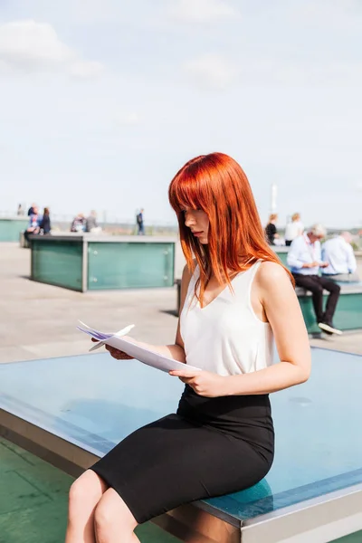 Young redhead business woman in formal outside