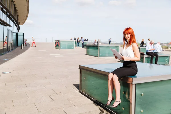 Mulher empresária senta-se ao sol com papéis nas mãos — Fotografia de Stock
