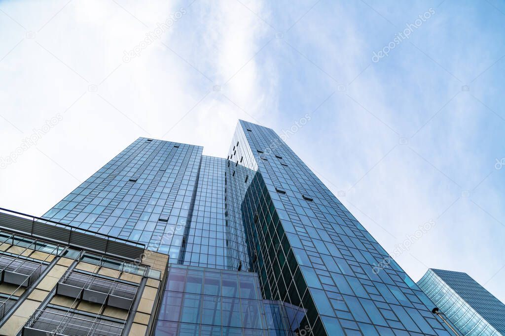 Bottom view of blue skyscraper with glass walls