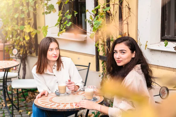 Duas mulheres bebem café no café e posam para câmera — Fotografia de Stock