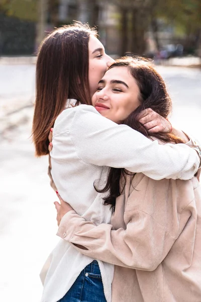 Encuentro de dos amigas con abrazo en la ciudad —  Fotos de Stock