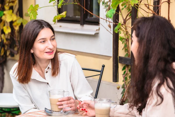 Duas mulheres bebem café no café e posam para câmera — Fotografia de Stock