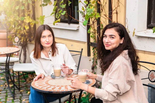 Dos mujeres toman café en la cafetería y posan para la cámara —  Fotos de Stock