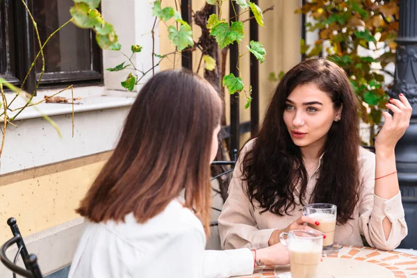 Meninas amigos conversando sobre xícara de café no café — Fotografia de Stock