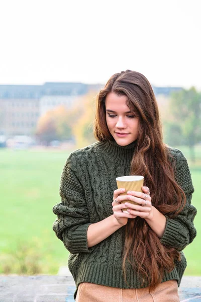 손에 커피를 들고 야외에 있는 소녀의 모습 — 스톡 사진