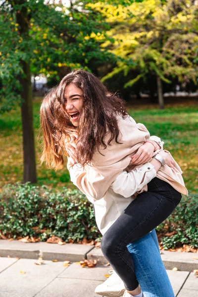 Chica abraza a su mejor amigo firmemente en el parque al aire libre —  Fotos de Stock