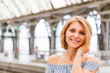 Tren istasyonunda sarışın bir kızın yakın plan portresi.