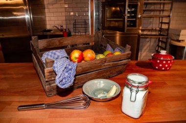 Mutfak gereçleri, olgun elma, tencere, kavanozda şeker ve tereyağı dolu ahşap kutu.