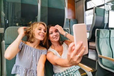 Trende selfie çeken iki kız arkadaş.