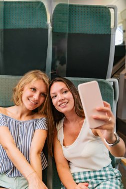 Trende selfie çeken iki kız arkadaş.