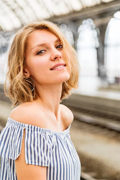 Retrato de una mujer rubia sonriente de pie a media vuelta — Foto de Stock