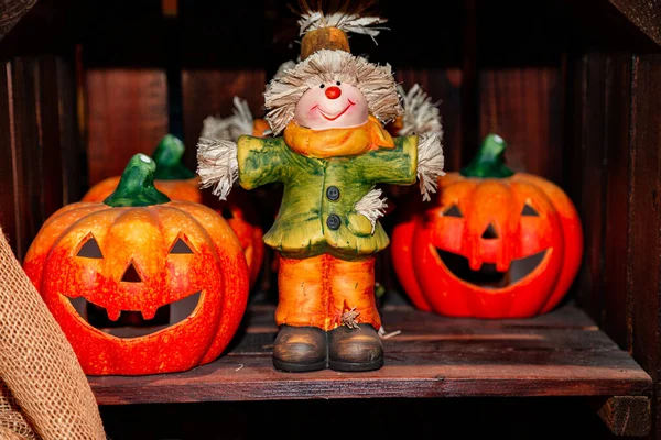 Orangefarbene Keramik-Kürbisköpfe und Vogelscheuche für Halloween im Geschäft — Stockfoto