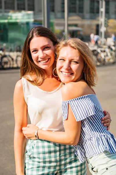 Mujer rubia abraza a su amigo y sonríe a la cámara —  Fotos de Stock