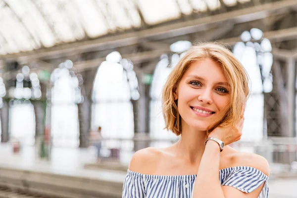 Tren istasyonunda sarışın bir kızın yakın plan portresi.