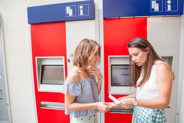 Elinde biletleri olan iki genç kız arkadaş.