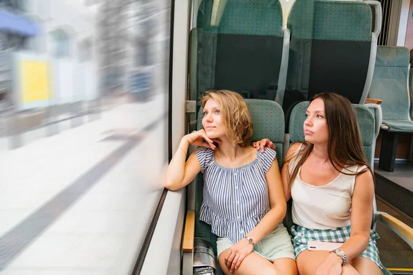 Meninas em roupas de verão sentadas no trem pela janela — Fotografia de Stock