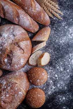 Fırın ekmek üreticileri - altın rustik huysuz somun ekmek ve siyah kara tahta zemin üzerine buns. 