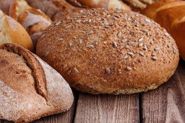 Ahşap masa arkasında pişmiş ekmek çeşitleri