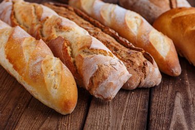 Ahşap masa arkasında pişmiş ekmek çeşitleri