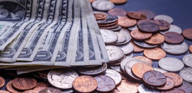 Amerikan paraları ve dolarlarımız siyah bir masanın üzerinde.