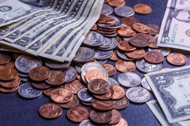 Amerikan paraları ve dolarlarımız siyah bir masanın üzerinde.