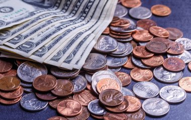 Amerikan paraları ve dolarlarımız siyah bir masanın üzerinde.